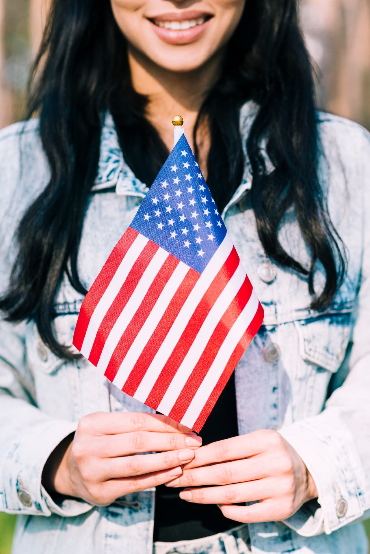 A smiling community member holding a small American flag